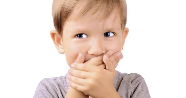 cheerful boy 5 years shut by the hands mouth